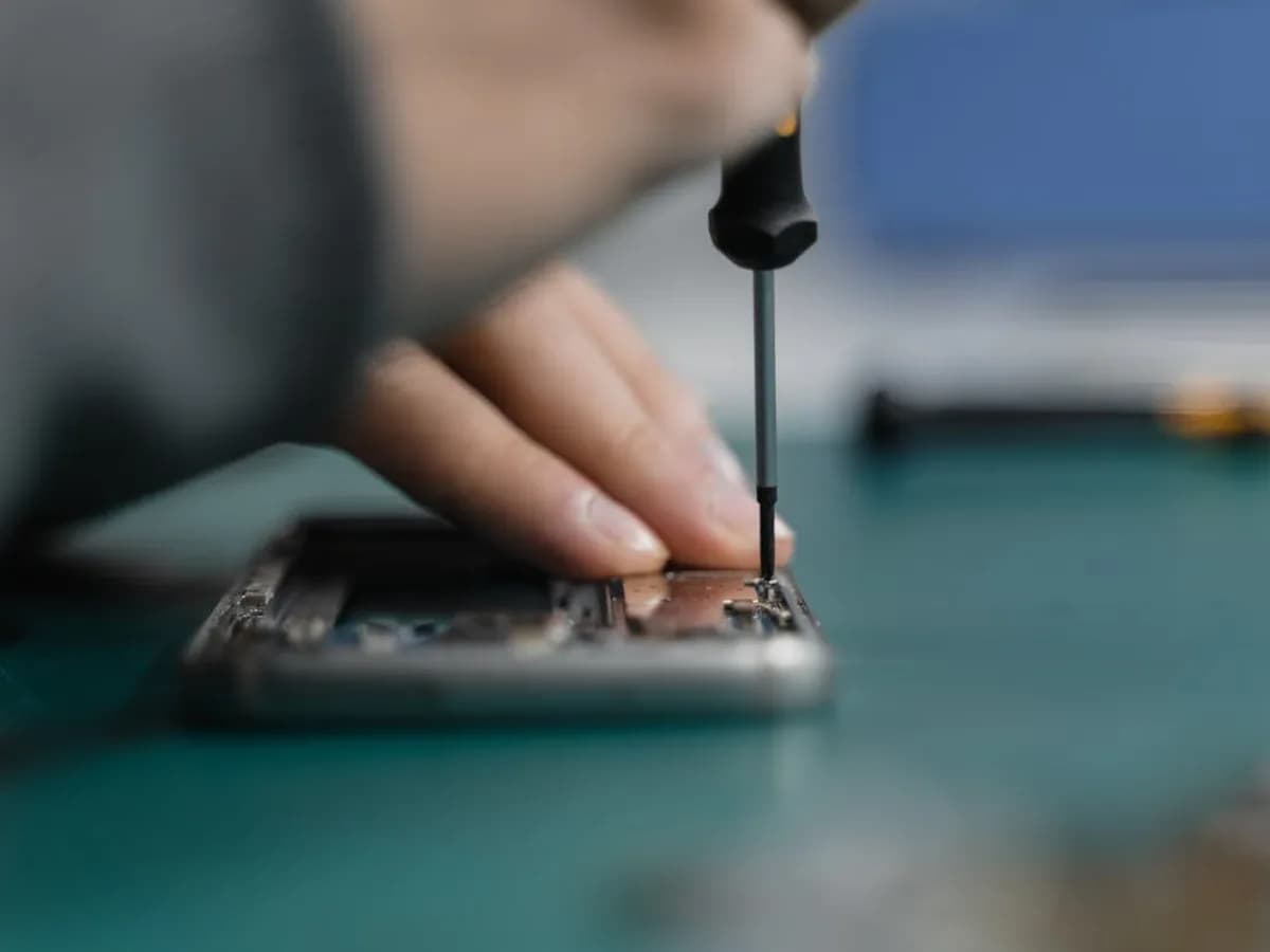 Techniker bringt eine Hydrogel-Folie auf ein Smartphone an